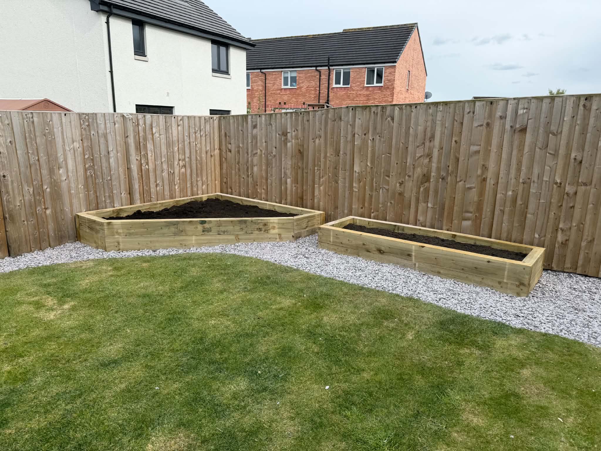 Finished landscaped garden with timber raised beds, paving and slate